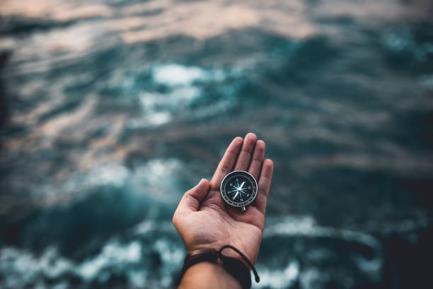 Compass on hand Compass, navigational compass, travel compass, lost compass, navigational equipment photos stock pictures, royalty-free photos & images