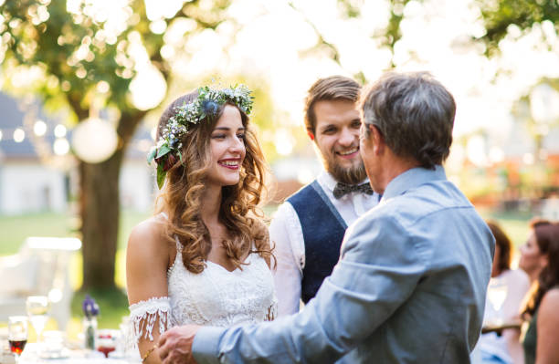 istock A father congratulating bride and groom at wedding reception in the backyard. 985900508