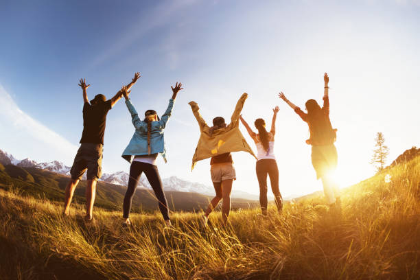 istock Group happy friends mountains sunset raised arms 985900736