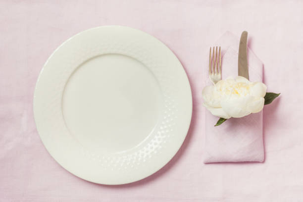 istock Romantic dinner. Elegance table setting with plant on pink linen tablecloth. Top view. 985903880