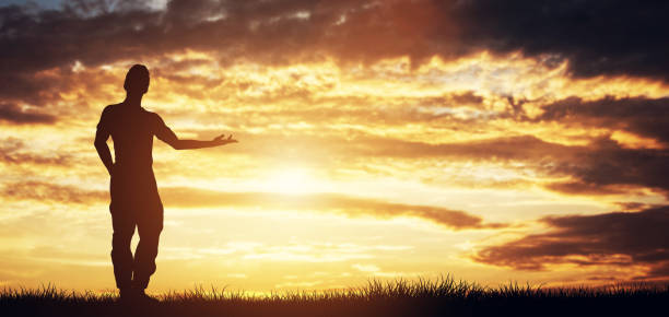 istock Casual man standing in front of the sky pointing right 985909820