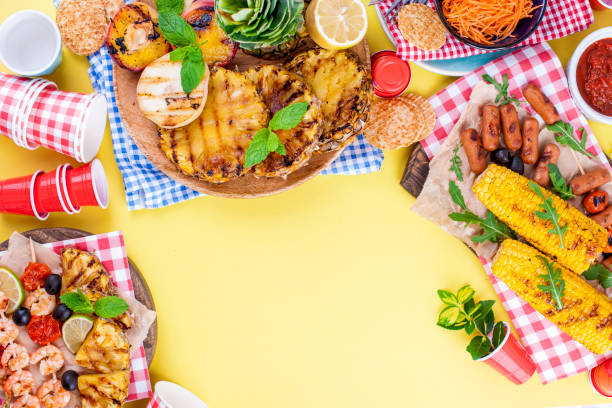 istock Different fruits and vegetables are cooked on the grill. Yellow background. Summer dinner. . Copy space. 985909848