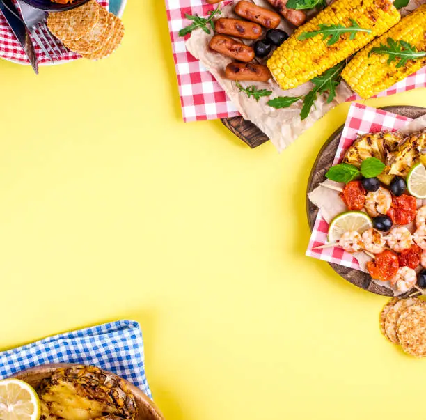 Different fruits and vegetables are cooked on the grill. Yellow background. Summer dinner. . Copy space. flat lay.