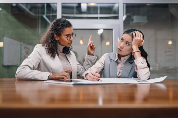 istock tired and serious multiethnic businesswomen working with documents in office 985921174