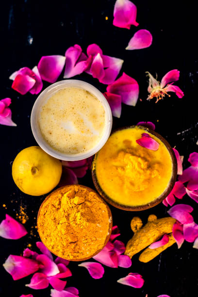 Chana,haldi,limbo & milk  ka ubtan or ayurvedic face pack of Turmeric, Lemon,gram flour & milk on wooden surface for good skin and no black heads or any skin related problems. stock photo