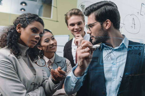 istock executive multiethnic businesspeople working with glass board in office 985927308