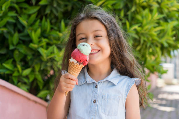 istock Cute little girl eating an ice cream 985936330
