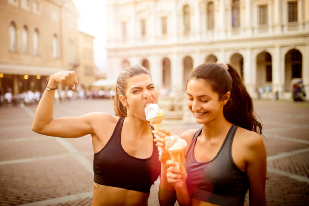 istock Two sporty women eating ice cream. 985948174