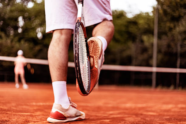 istock Tennis player removing clay from his sneakers 985948238