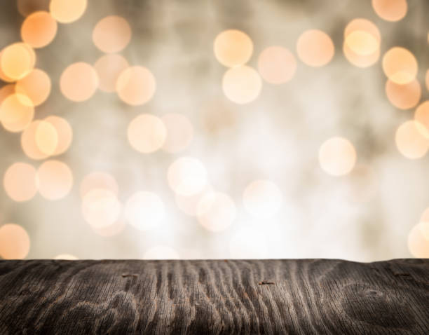 istock Rrustic wood table in front of glitter and bright bokeh lights 985954622