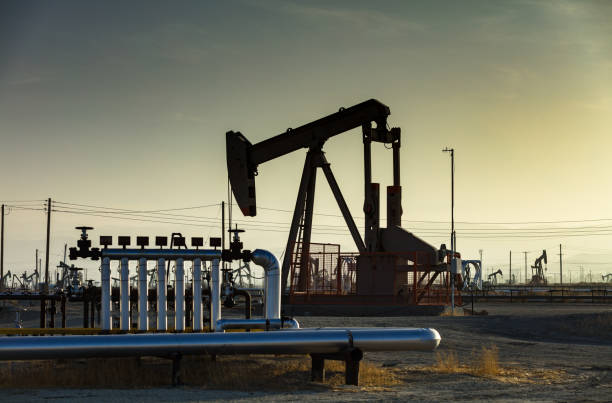 Oil pumps silhouetted against the setting sun in the hazy California Central Valley, near Bakersfield.