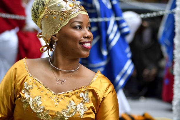Annual Juneteenth Parade and Festival in Philadelphia, PA Philadelphia, PA, USA - June 23, 2018; Female in traditional attire smiles as she participated in the annual Juneteenth parade in Center City Philadelphia, PA, on June 23, 2018. The Juneteenth Independence Day or Freedom Day commemorates the announcement of abolition of slavery on June 19, 1865. parade photos stock pictures, royalty-free photos & images