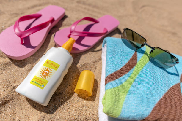 istock Beach essentials - sun cream, towel, flip-flops, sunglasses 985967134