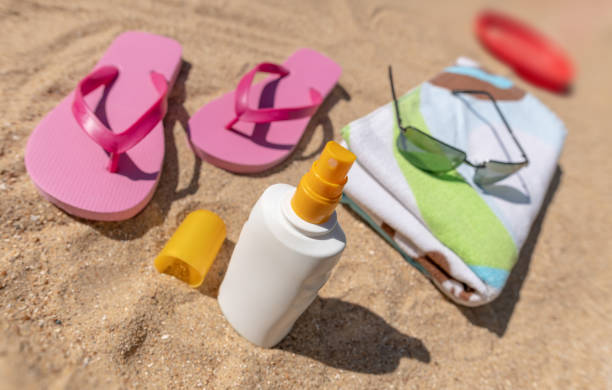 istock Flip-flops, towel, sun cream, sunglasses on a sandy beach 985971494