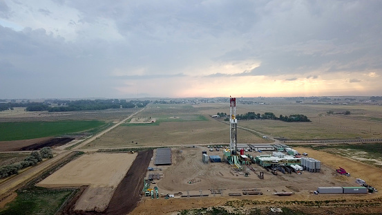 Beautiful image of a fracking drilling rig before a moody stormy sunset sky in Eastern Colorado.