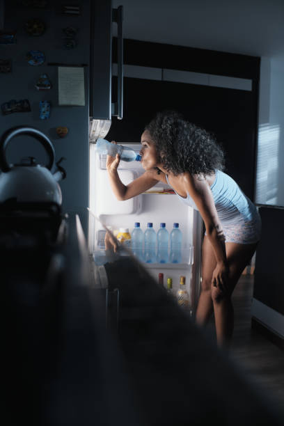istock Black Woman Sweating And Drinking Water At Night 985984128
