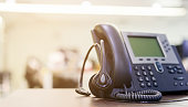 close up focus on call center headset device at telephone VOIP system at office desk for hotline telemarketing concept
