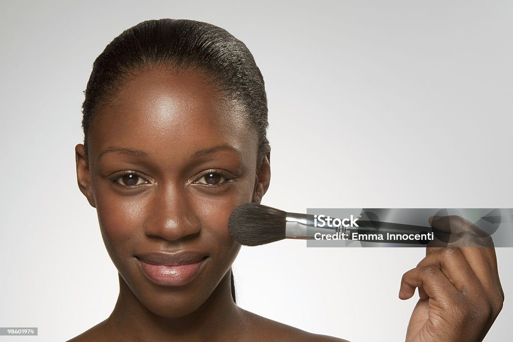 Young woman with make up brush on chick woman, young woman, beauty, close up, studio shot, make up, face up, clean, skin looking at camera, brush, make up brush, white background, foundation brush, smiling, happy, applying make up, landscape, tied hair 20-24 Years Stock Photo