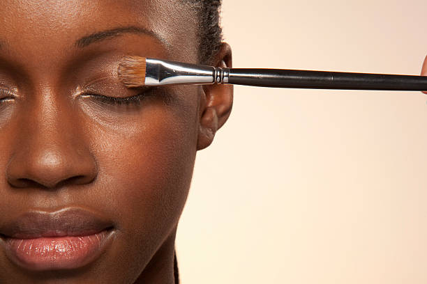 Woman with eye make up brush on eye woman, young woman, beauty, close up, studio shot, make up, face up, clean, skin brush, make up brush, eyes closed, relaxed, no make up, one eye, applying stock pictures, royalty-free photos & images