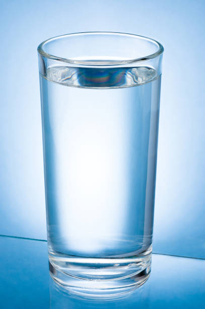 istock Glass of Water isolated on a blue background 986035664