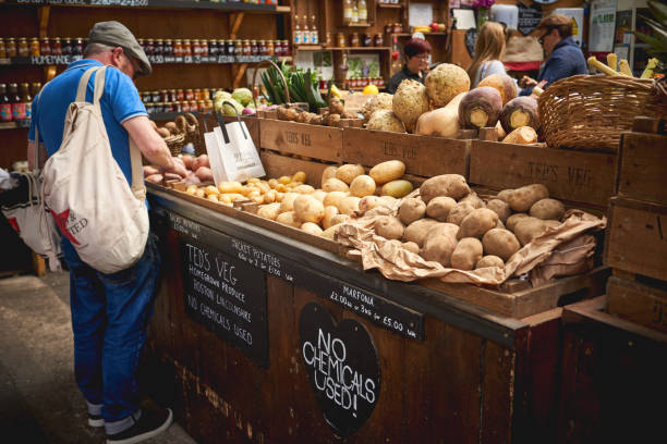 diverse varietà di patate biologiche in vendita in una bancarella di verdure a borough market, uno dei più antichi e grandi mercati alimentari di londra. - editorial horizontal farmer occupation foto e immagini stock