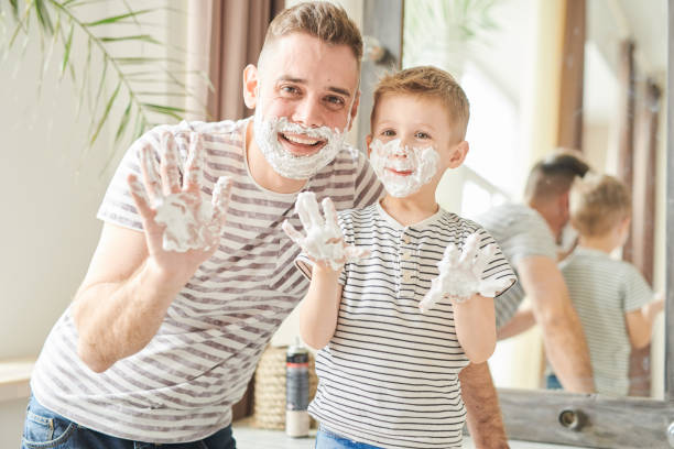 istock Funny Father and Son Covered in Shaving Foam 986044656