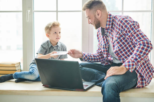 istock Cute Son Giving Fathers Day Card to Dad 986044660