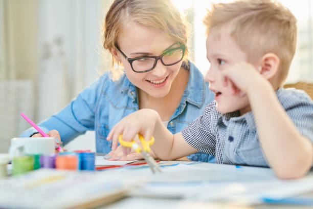 istock Happy Mother and Son Crafting Together in Sunlight 986044754