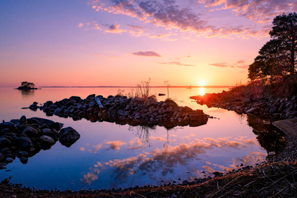 istock Beautiful sunset with lovely clouds reflected in the lake 986056302