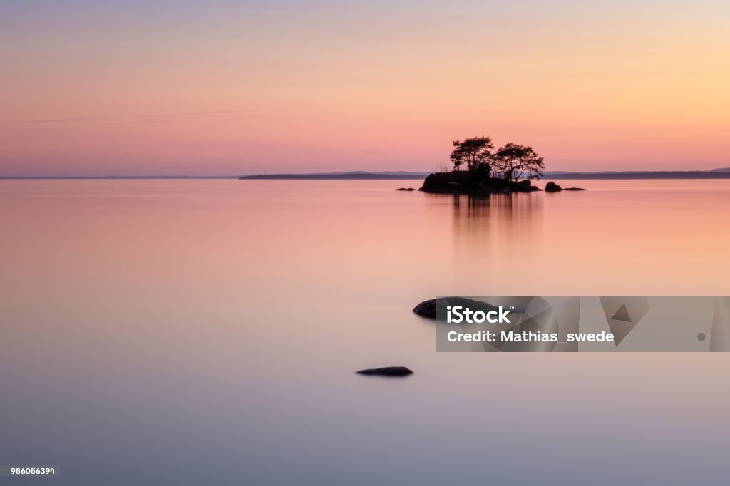 Beautiful colors with stones in the lake and a small island in the back Lake Stock Photo