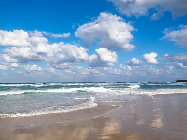 istock Waves spread on a sandy Black Sea beach, cloud reflections on the sand, cumulus clouds in the sky 986067462