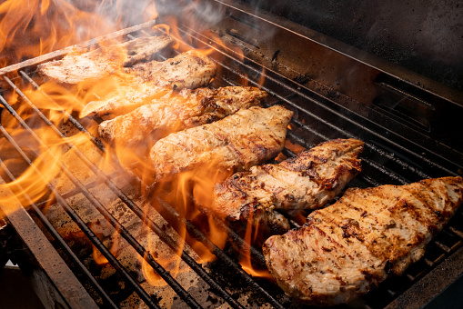 Fiery grill full of perfect chicken breasts