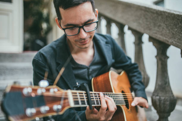 istock Man with differing abilities playing acoustic guitar outdoors 986100826