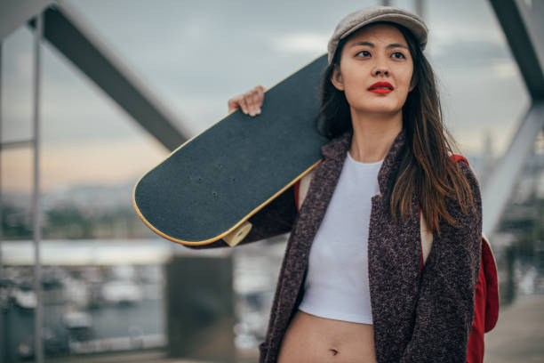 istock Woman carrying skateboard 986108092