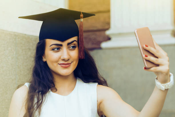 istock Happy graduate girl taking a selfie 986115402