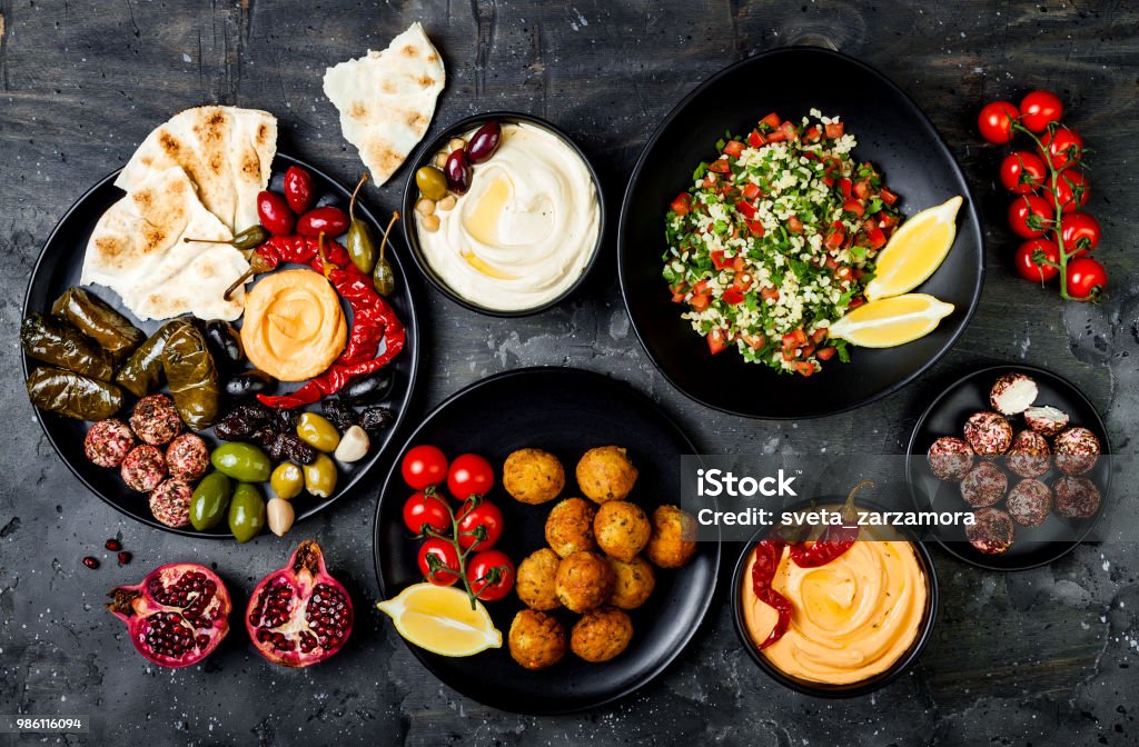 Arabic traditional cuisine. Middle Eastern meze platter with pita, olives, hummus, stuffed dolma, labneh cheese balls in spices. Mediterranean appetizer party idea Food Stock Photo
