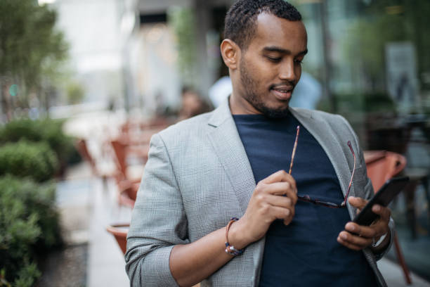 istock Man in coffee shop texting on phone 986116232