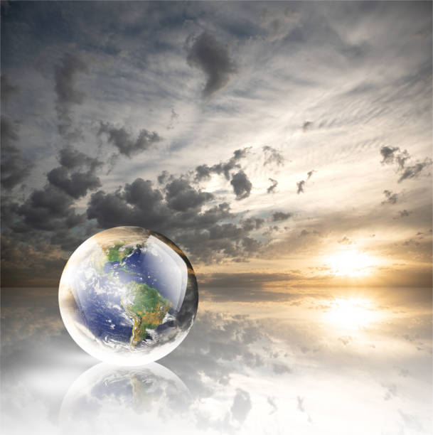 istock Crystal ball reflecting globe of the earth on sunset with clouds background 986126120