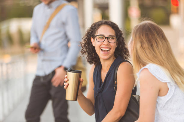 istock Female colleagues wait together a public transit station 986126426