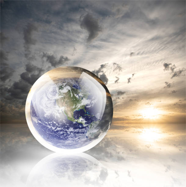 istock Crystal ball reflecting globe of the earth on sunset with clouds background 986138600