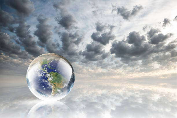 istock Crystal ball reflecting globe of the earth on clouds background 986140732