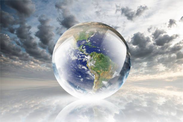 istock Crystal ball reflecting globe of the earth on clouds background 986148400