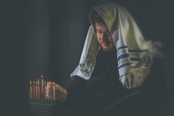 ハヌカ、ユダヤ人の祭典。蝋燭が燃えて、本枝の燭台の背景の人。 - menorah hanukkah candle human hand ストックフォトと画像