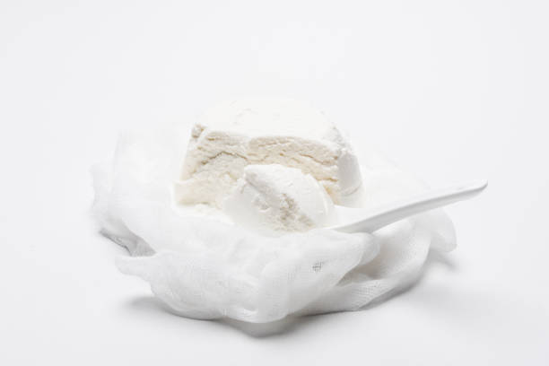 istock delicious cottage cheese on cheesecloth with spoon on white surface 986157764