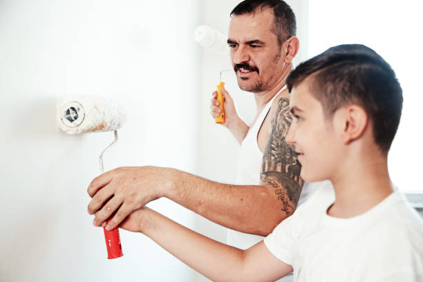 istock Father and son working putting plaster on a wall 986164392