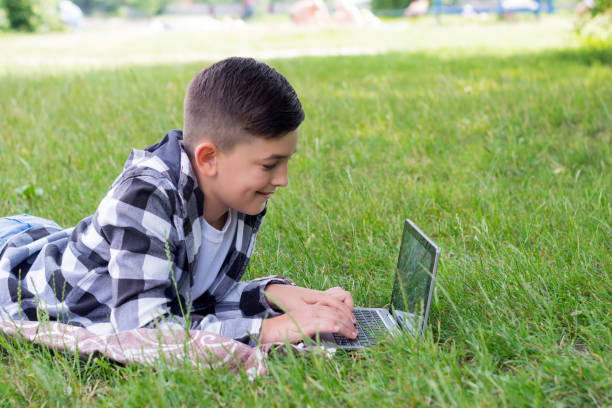 istock Young boy with laptop outdoors 986168878
