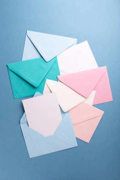 envelopes coloridos na mesa cinza. - envelope opening stack open - fotografias e filmes do acervo