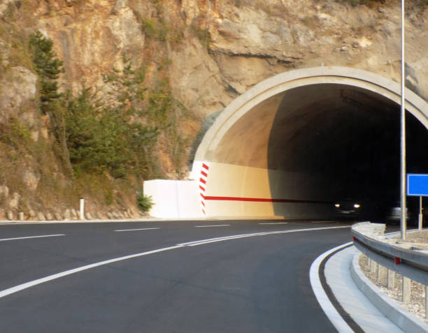 la voiture quitte le tunnel sur l’autoroute - highway underground corridor street photos et images de collection