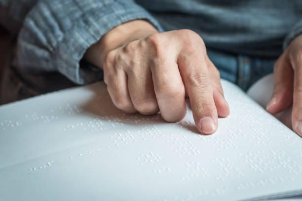 livro de braille para baixa visão / pessoa cega lendo braille sinal dedo tocando em relevo papel de textura para o dia mundial da visão e o conceito de consciência dia mundial de braille - eyesight senior adult care support - fotografias e filmes do acervo