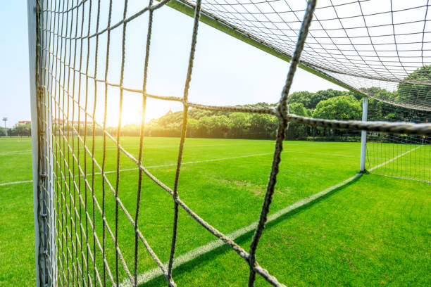 istock Green football field under blue sky 986213146
